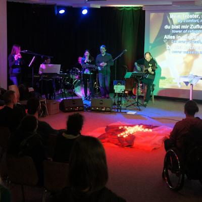 Die Lobpreisband spielt auf der Bühne, das Licht ist gedämpft